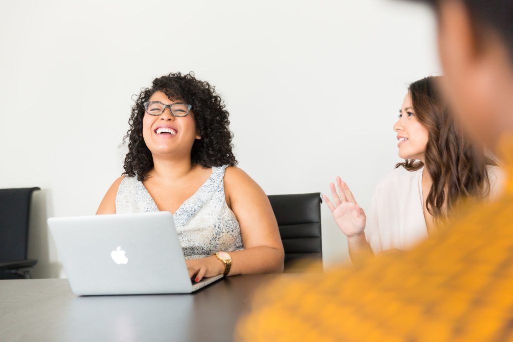 writer in the office on laptop laughing