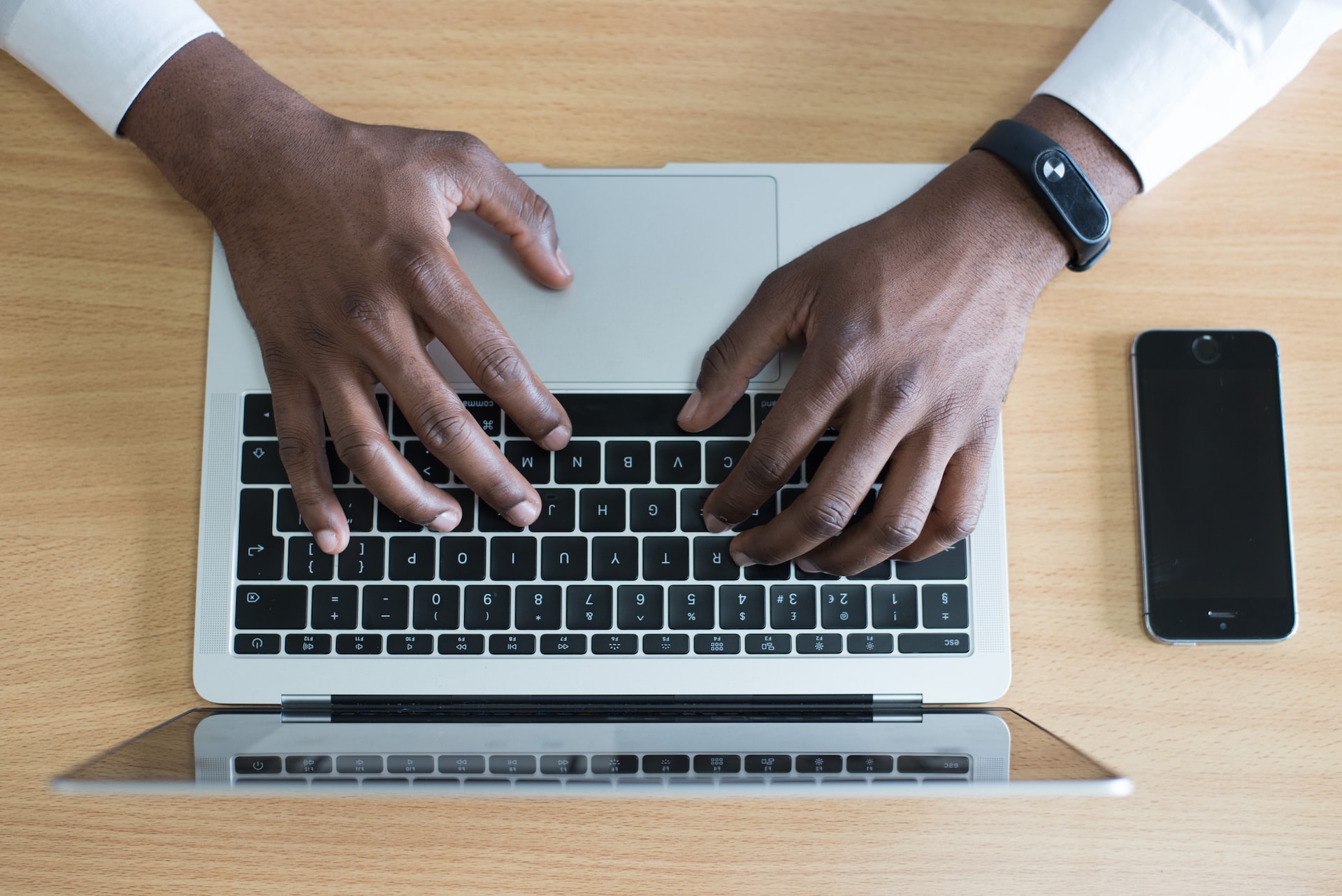 man typing on laptop birdseye view