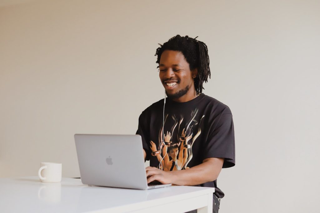 man typing on laptop while smiling