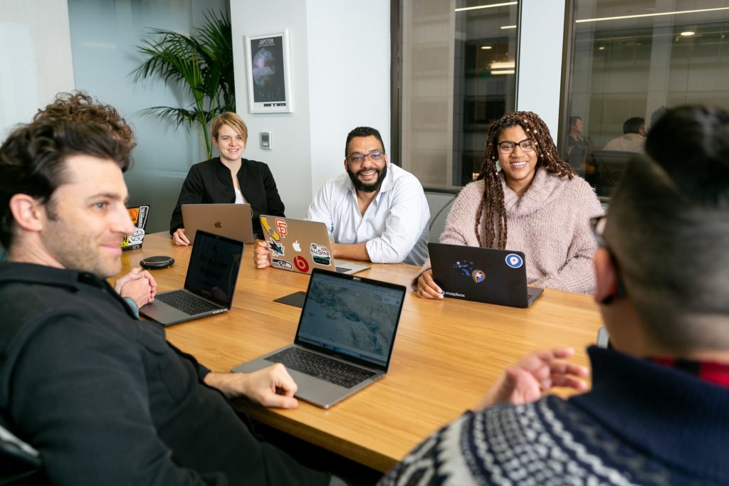 group of people smiling working in conference room