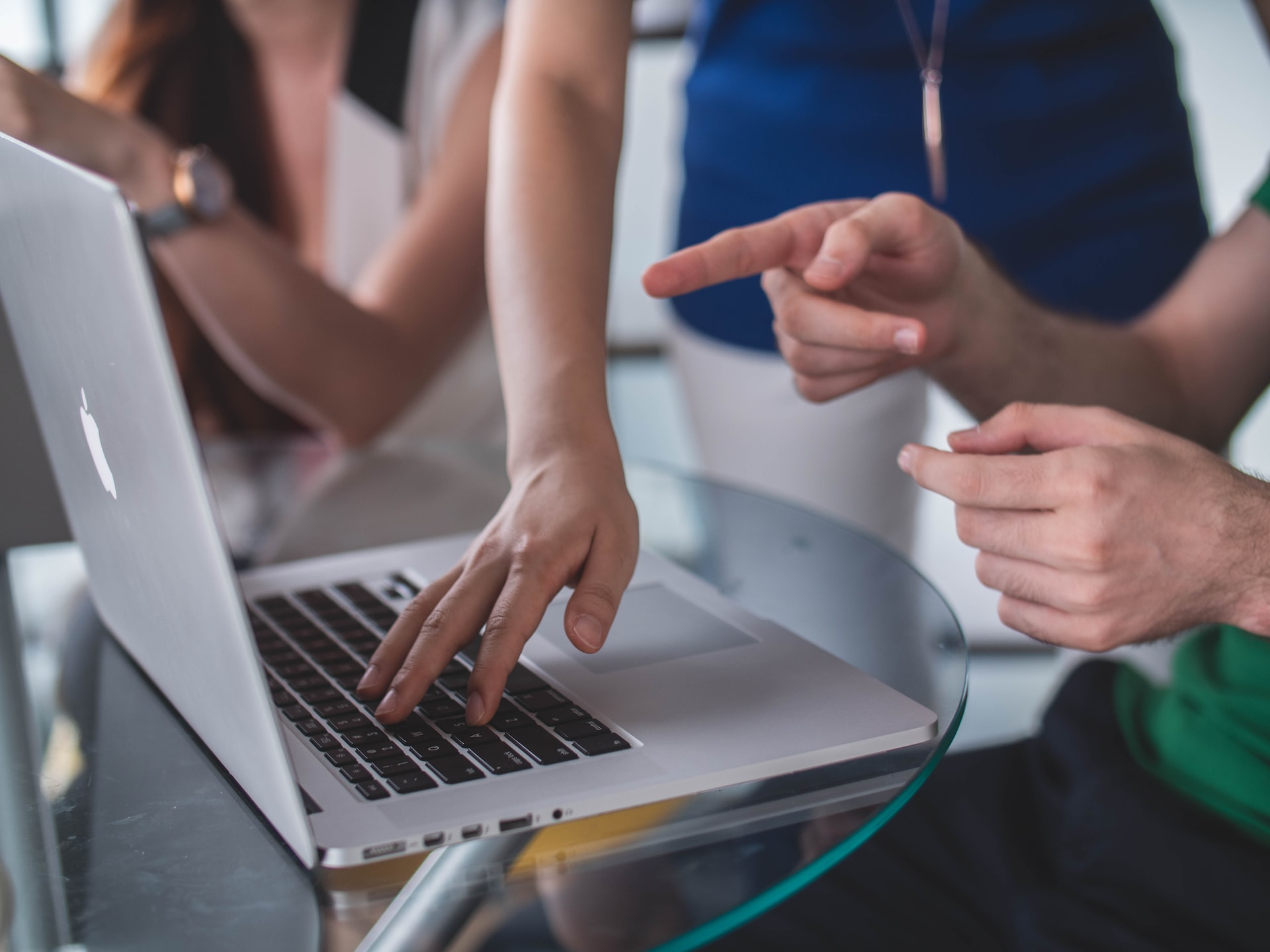 person pointing at a laptop