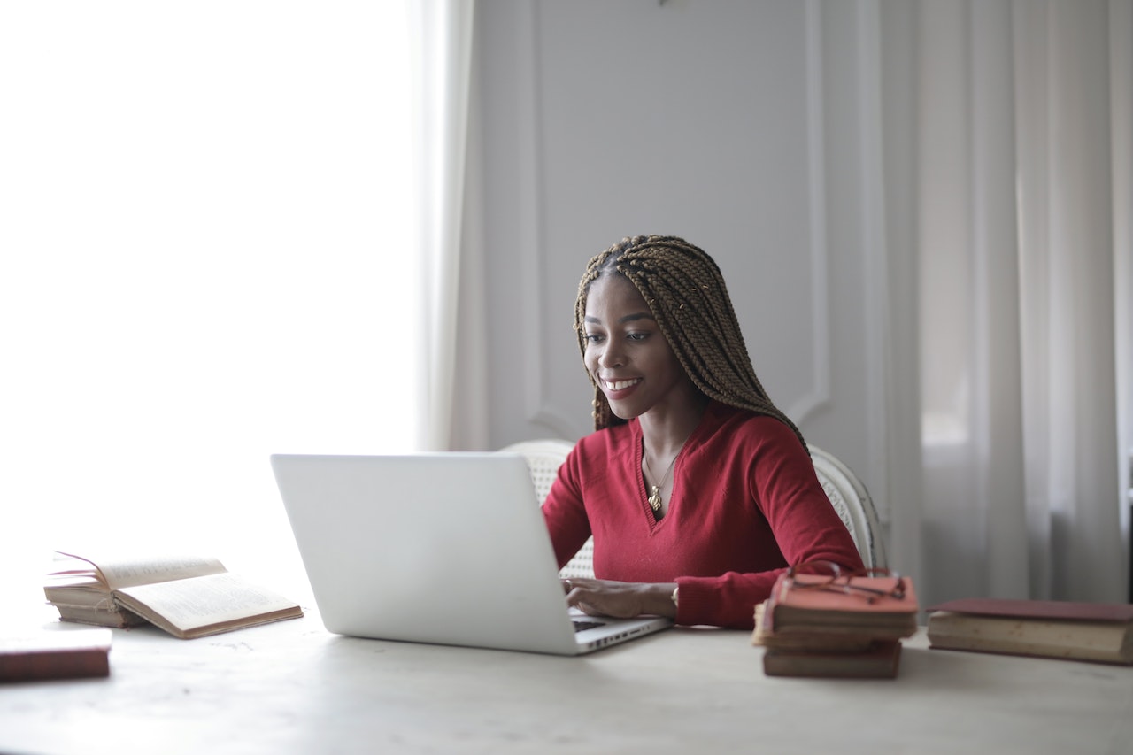 woman smiling and typing on laptop