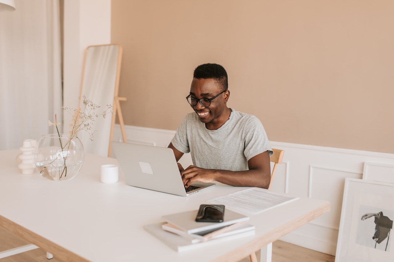 man in office typing on macbook