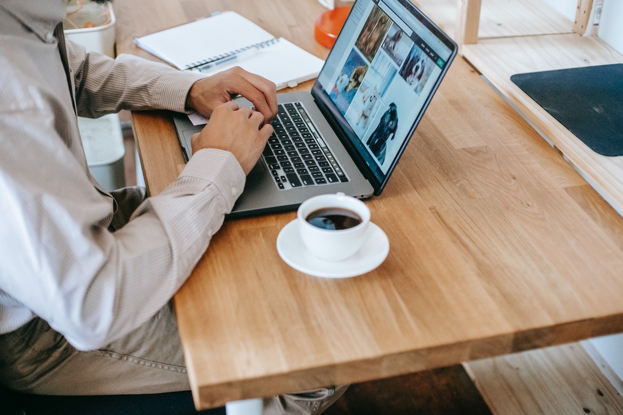 salesperson typing on his laptop with coffee